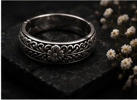 Carved sterling silver bangle on dark stone