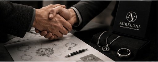 Business handshake over AURELUNE jewellery, sketches and a branded silver box
